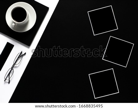 Black and white work space with cup of coffee and empty photo frames. Minimal black work space.