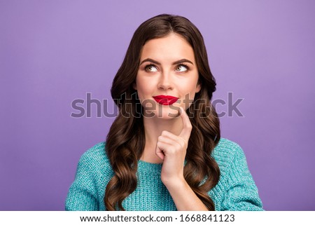 Closeup photo of charming wavy lady red lips good mood look up empty space hold arm on chin dreamer wear blue warm sweater isolated purple color background