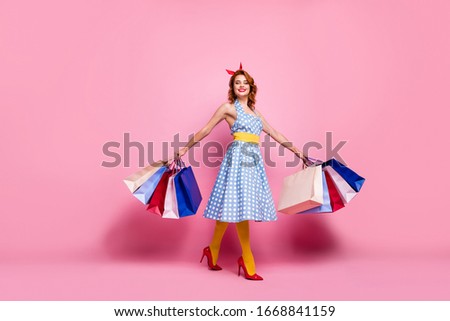 Full size photo cheerful tender elegant cute pretty girl summer weekend go shopping hold many bags enjoy purchase wear blue headband yellow tights red stilettos isolated pink color background