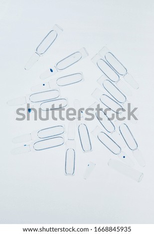 Top view background image of glass ampules scattered on white table in laboratory, copy space