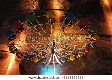 
illuminated night park with Ferris wheel, carousel and roller coaster