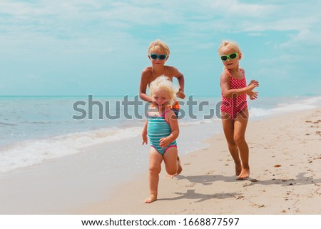 happy kids enjoy beach vacation, boy and girls have fun