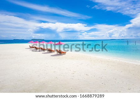 Beautiful tropical beach banner. White sand with loungers, sun beds and umbrella travel tourism wide panorama background. Amazing beach landscape. Luxury island resort vacation or holiday