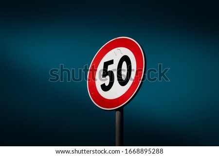 50 miles or kilometers for hour limit. Road sign, urban design, street language, deep blue sky.