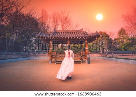 Asian korean Girls dressed Hanbok in traditional dress at sunset in South Korea. Royalty-Free Stock Photo #1668906463