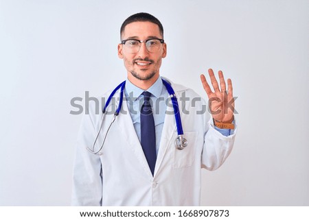 Young doctor man wearing stethoscope over isolated background showing and pointing up with fingers number four while smiling confident and happy.