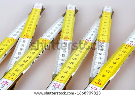 A yellow folding rule on white background Royalty-Free Stock Photo #1668909823