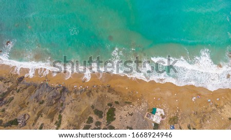 Turquoise water of the Mediterranean Sea top view.Summer holiday by sea.Aerial view of sandy beach,waves and coastline of Crete.Relaxation in tropical paradise.Travel vacation background copy space