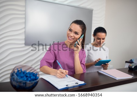 Call from client. Receptionist of beauty clinic receiving call from client in the morning Royalty-Free Stock Photo #1668940354