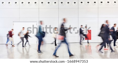 Many anonymous blurred people go shopping in the mall or airport