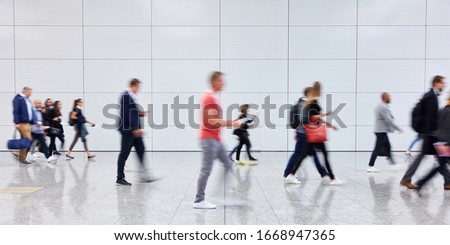 Anonymous blurred people go into shopping mall or airport
