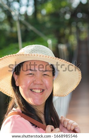 Portrait of happy Asian Chinese girl with straw hat in the outdoor park - Nature travel Concept