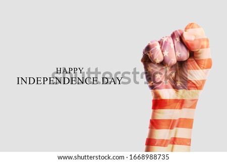 Double exposure of hand with clenched fist and USA flag on light background. Independence Day celebration
