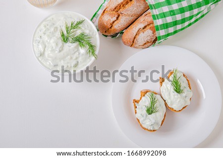 Greek appetizer (salad) - tzatziki. Yogurt, fresh cucumbers and dark (buckwheat) bread (baguette). Healthy healthy diet. Light snack.