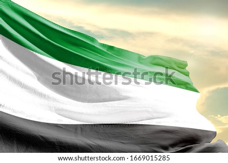 Comoros national flag cloth fabric waving on the sky with beautiful sun light - Image