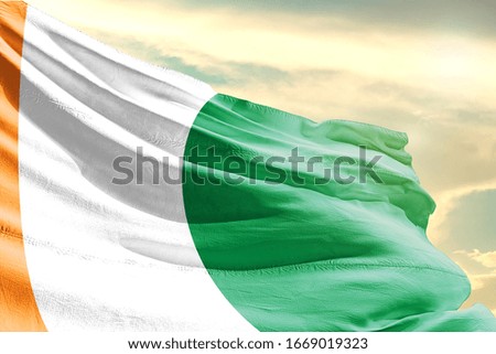 Ireland national flag cloth fabric waving on the sky with beautiful sun light - Image