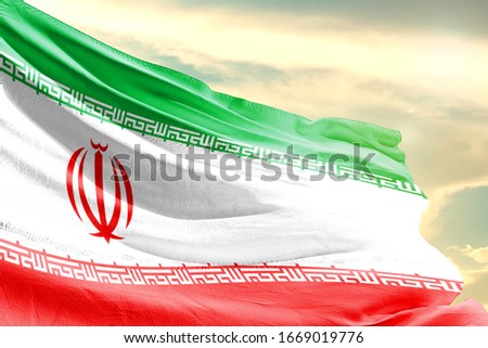 Iran national flag cloth fabric waving on the sky with beautiful sun light - Image