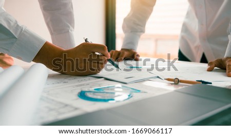 Engineering man showing blueprint detail for people buying house.