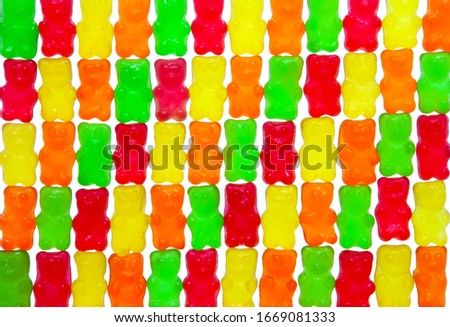Background from multi-colored marmalade bears. Jelly bears in colored rows.