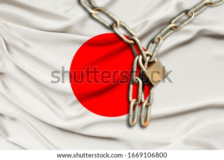 iron chain and castle on the silk national flag of japan with beautiful folds, the concept of a ban on tourism, political repression, crime, violation of the rights and freedoms of citizens
