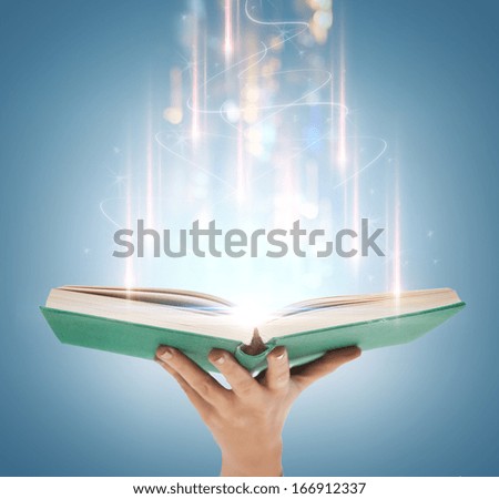 education and book concept - close up hand holding open book with magic lights Royalty-Free Stock Photo #166912337