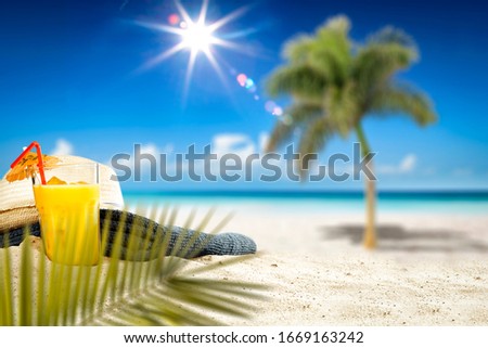 Fresh cold drink on hot sand and blurred landscape of beach with sea.Blue sky and sunny day. 