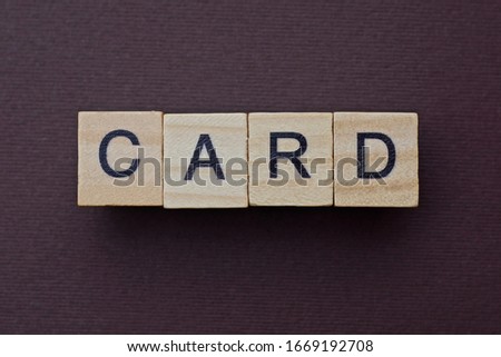 gray word card from small wooden letters on a brown table