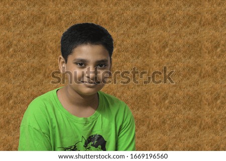 Boy wearing a green T-shirt and smiling
