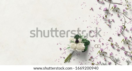 bouquet of flowers and rings with decorative flower petals on paper background
