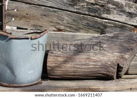 Rustic still life: old bucket and log.