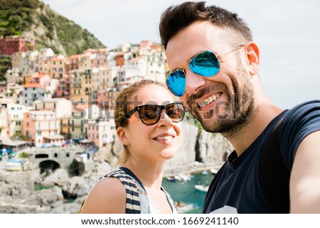 Young couple taking a selfie in Manarola, Cinque Terre in Italy