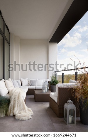 Elegant designed balcony with stylish rattan furniture and many comfortable pillows and blanket Royalty-Free Stock Photo #1669244671