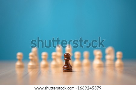 Brown chessman standing in front of white chess, Concept of a new startup must have courage and challenge in the competition, leadership and business vision for a win in business games Royalty-Free Stock Photo #1669245379