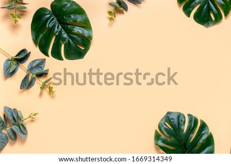 Tropical leaves on a beige background, top view, flat lay, free space for text. Leaves Background.