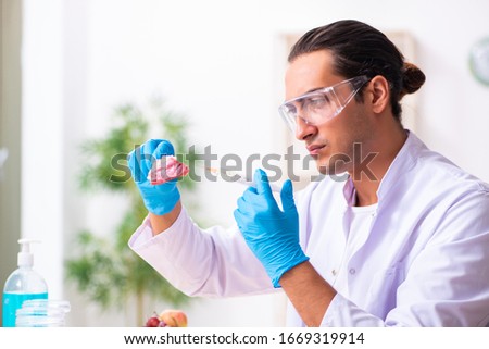 Young male nutrition expert testing food products in lab