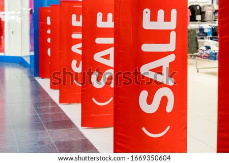 Big red sales poster on entrance clothing retailer.Discount sale label at shop entrance. Sale up to 50 percent.shopping mall.Season sale, black friday and shopping concept