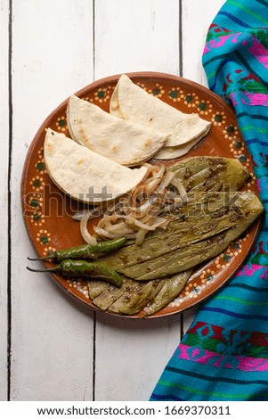 Traditional mexican grilled nopal cactus with quesadillas and serrano chili peppers on white background