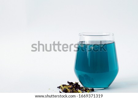 butterflu pea tea. glass of cold blue tea with dry flowers on a white background. blue herbal tea. Healthy lifestyle. Cold drinks. copy space