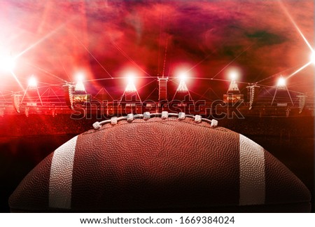 Football ball on red soccer stadium background
