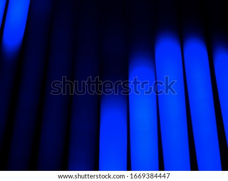 Sci Fi Futuristic Neon Lights Blue vertical dark background. Abstract cyan energy streams, thick vertical led lights and strips. Blue neon glow line. Fluorescent abstract wallpaper