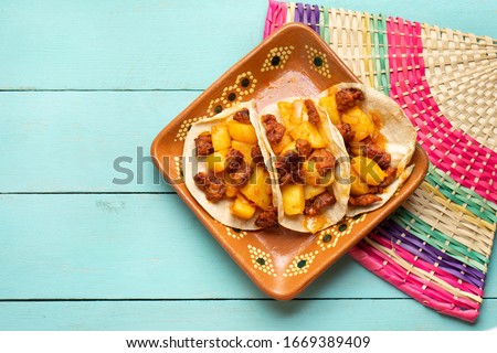 Traditional mexican chorizo with potatoes tacos on turquoise background
