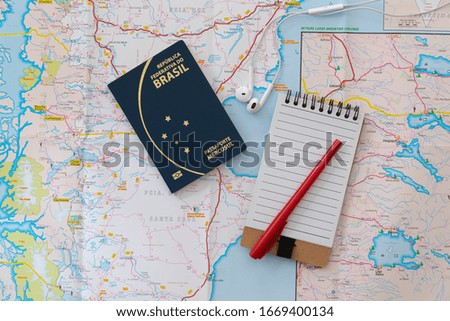 Brazilian passport, maps and holiday travel plans.