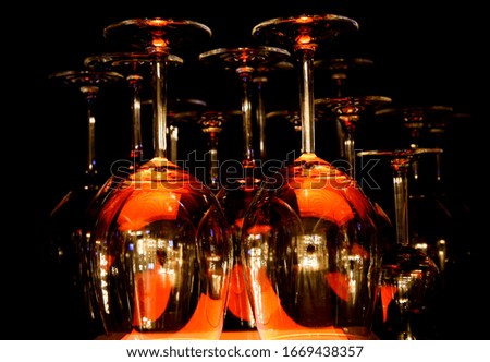 View on group of isolated red yellow shiny glowing wine glasses in cupboard