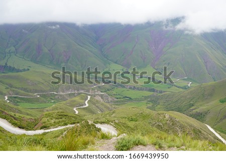 Scenic Road between cloudy mountains full of color near andes, in the north from Argentina, Salta, in the Cuesta del Obispo way, going Cachi, Royalty-Free Stock Photo #1669439950