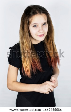 Portrait of a beautiful teenage girl with drawn hair. A girl has a sweet little sad face, she thinks about choosing a future profession, where to go to study. Vertical