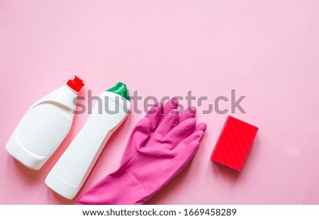 House cleaning and housekeeping concept. Cleaning supplies on pink  background. Cleaner detergent bottle, rag, sponge, rubber gloves. Top view and copy space Flat Lay 