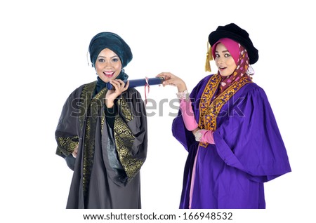 Young Beautiful Asian Muslimah graduate student wearing graduation cap and gown holding a diploma