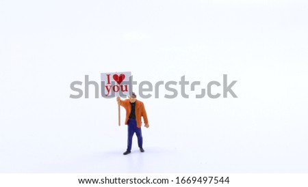  miniature toy  man with a banner saying i love you