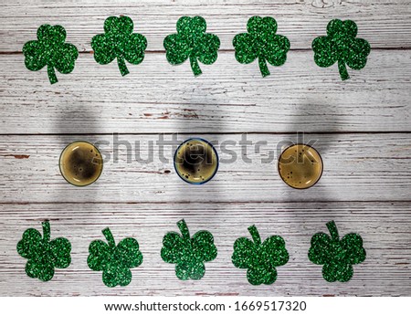 Flat lay composition with clover leaves and glasses of beer on wooden background. Saint Patrick's day