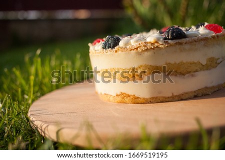 cake on wooden stand on grass background